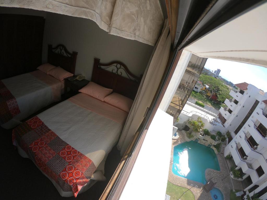 圣克鲁斯Suite 5 Estrellas的一间带两张床的卧室和一个带游泳池的阳台