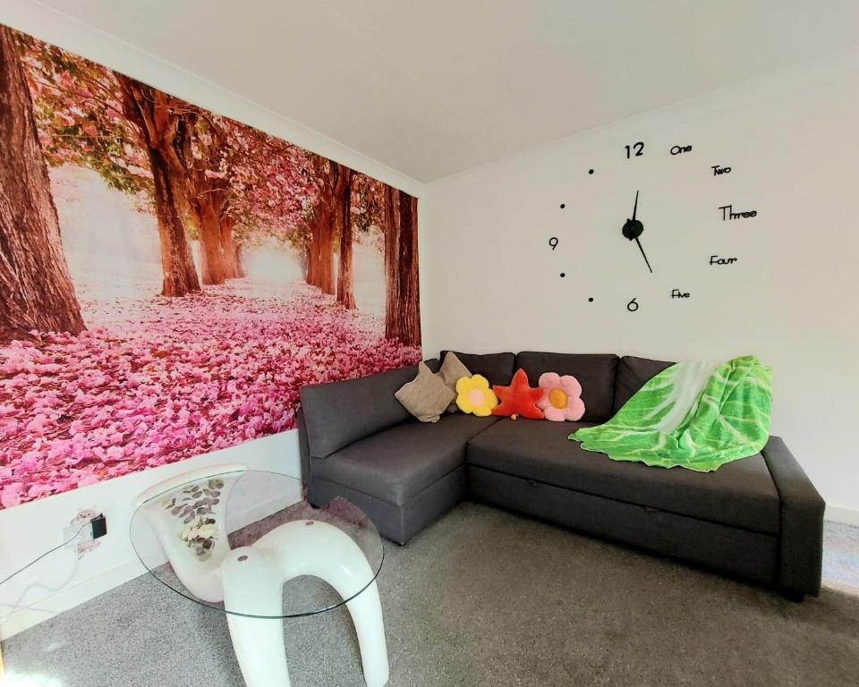 拉格斯The Blossom - Largs的客厅配有沙发和墙上的时钟