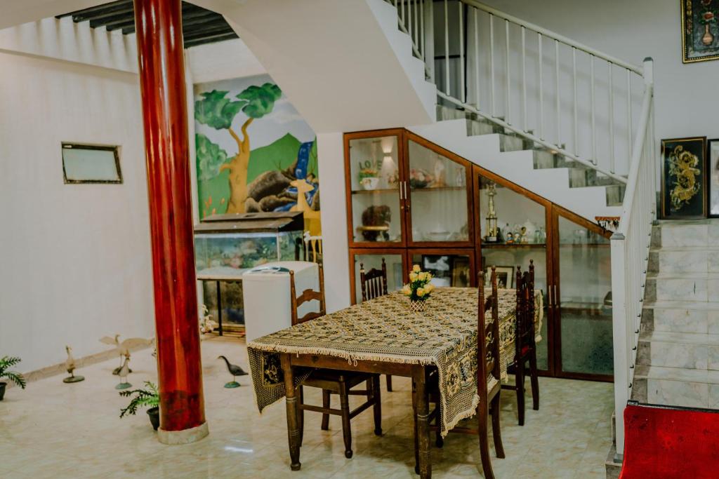 马特勒Lihini Villa ii的一间带桌椅和楼梯的用餐室