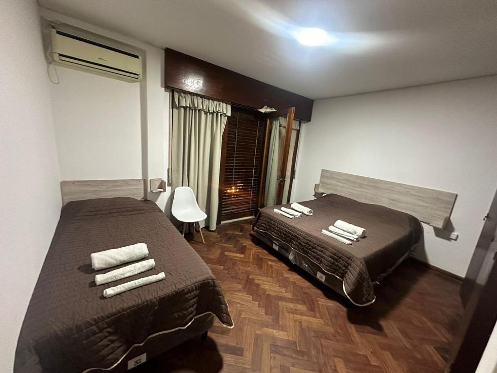 萨尔塔Hostal Vicente的酒店客房设有两张床和窗户。