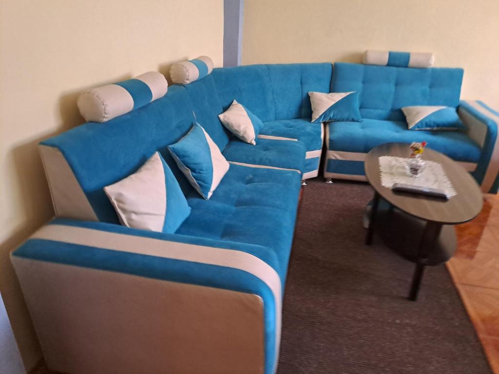 普诺Departamento Las Malvinas Puno的客厅配有一张蓝色的沙发,配有一张桌子