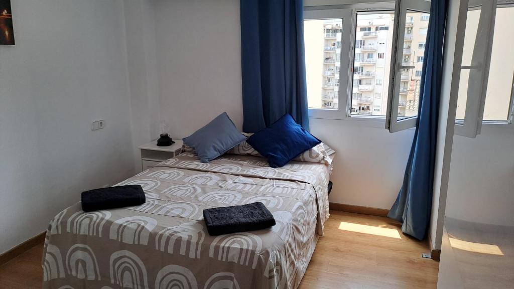 马略卡岛帕尔马Home & Away的小卧室配有带蓝色枕头的床
