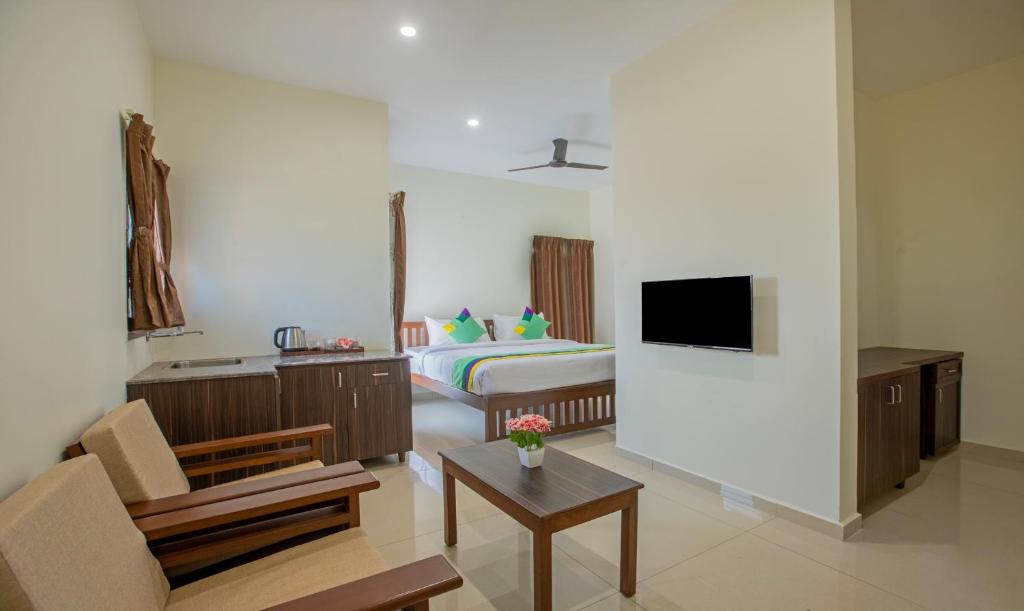 迈索尔Treebo Trend Samanvaya Retreat - Mysore的客房设有带一张床和电视的卧室。