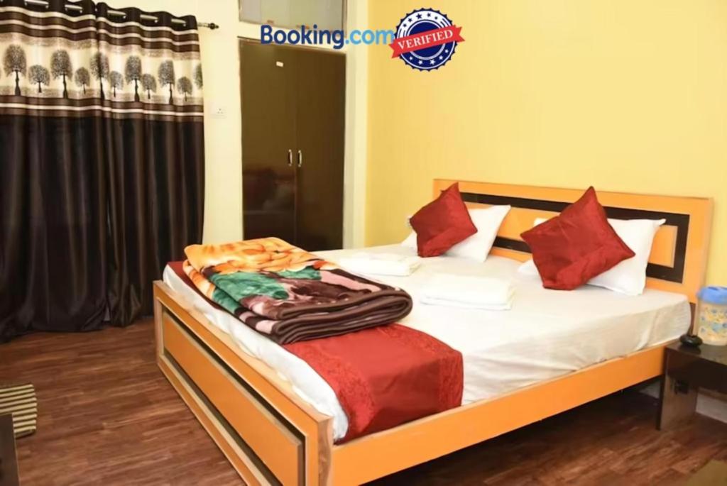 瓦拉纳西Goroomgo Varanasi Paradise Varanasi的一间卧室配有带白色床单和红色枕头的床。