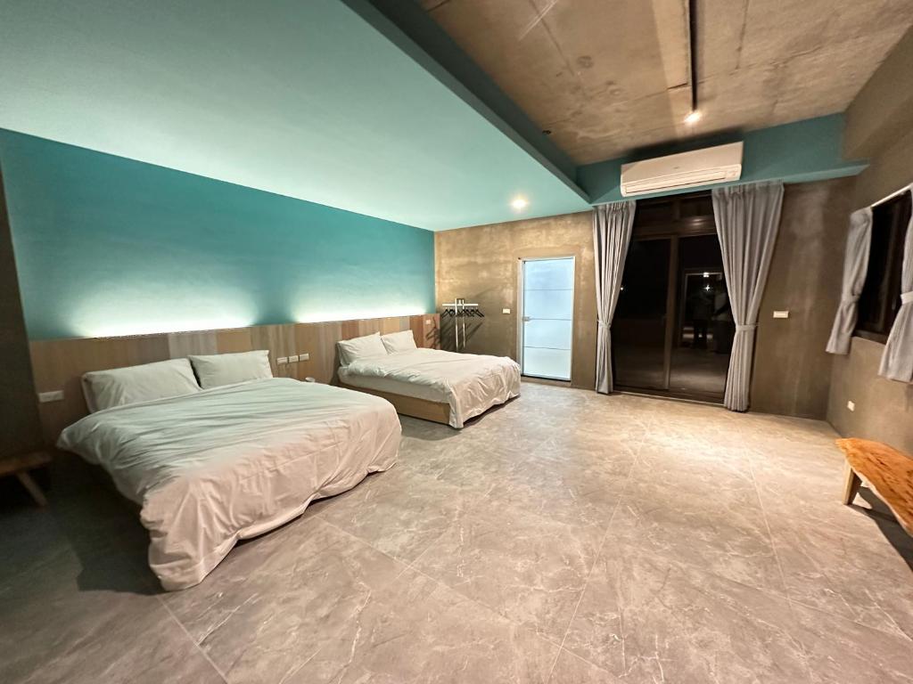 礁溪21稻香民宿的一间卧室设有两张床和蓝色的墙壁