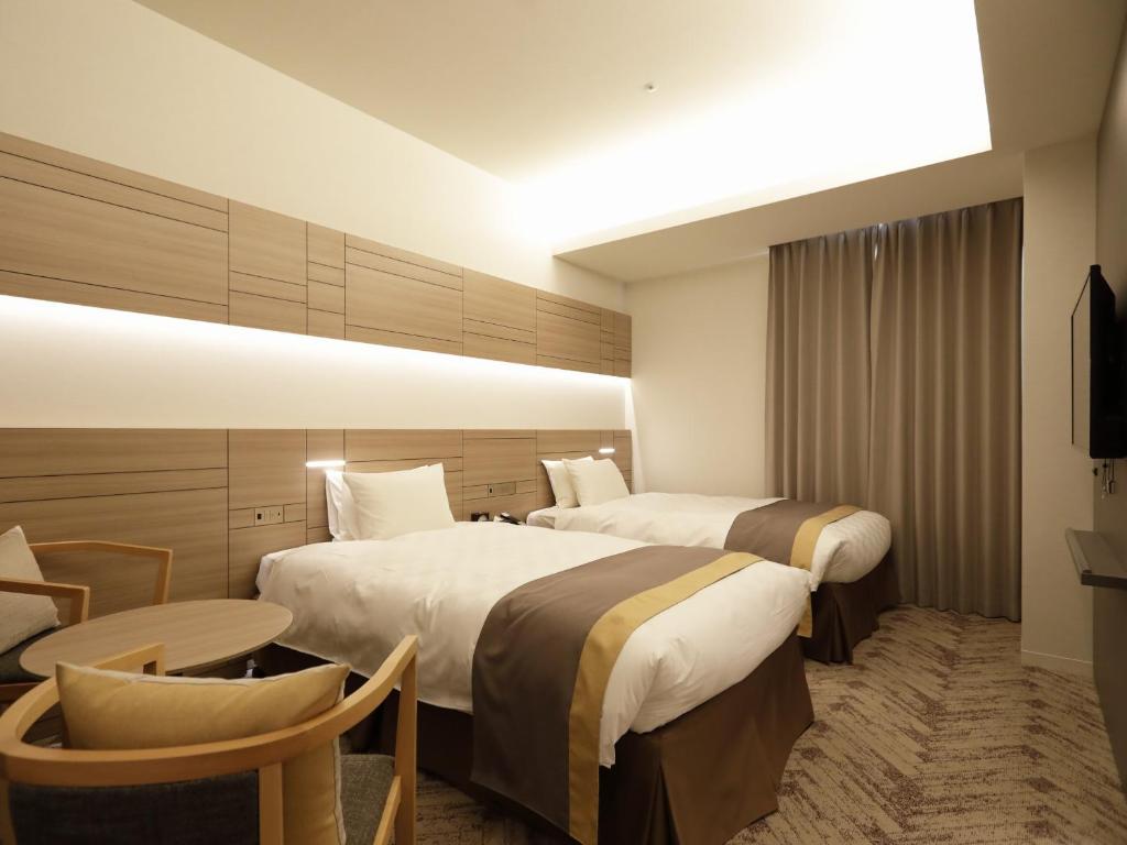 东京日本青年馆酒店的酒店客房设有两张床和一张桌子。