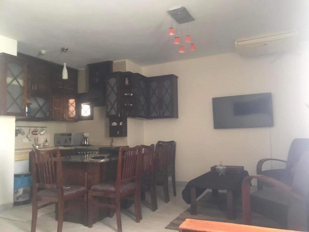 沙姆沙伊赫Criss Resort- Namaa Bay- Middle of Sharm的一间带桌椅的用餐室和一间厨房