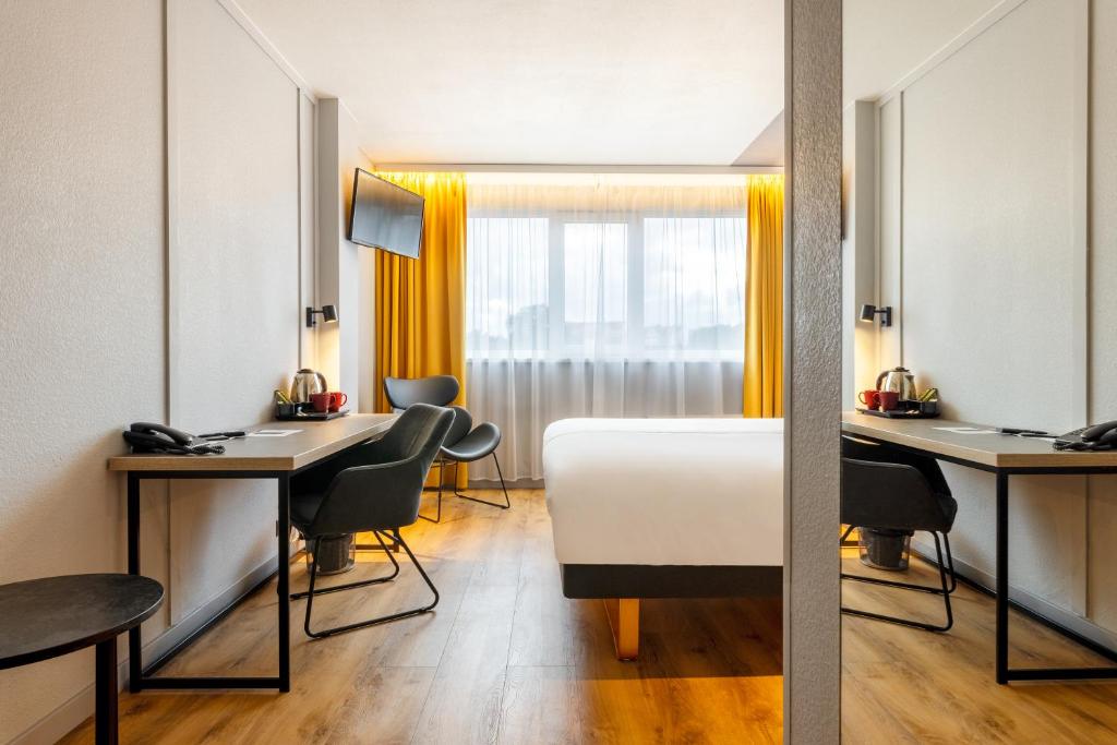 塔林大都市酒店的酒店客房,配有一张床、一张桌子和椅子