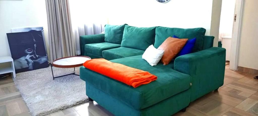 纳库鲁pgs plaz的客厅里配有带枕头的绿色沙发