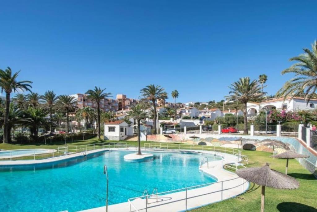托雷加迪亚罗Beach and Golf House Sotogrande - Torreguadiaro的度假村内一座种有棕榈树的大型游泳池