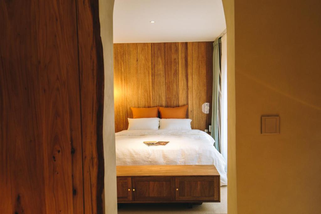 青岛禾煦的家-和煦 HX house的一间卧室配有一张木墙床