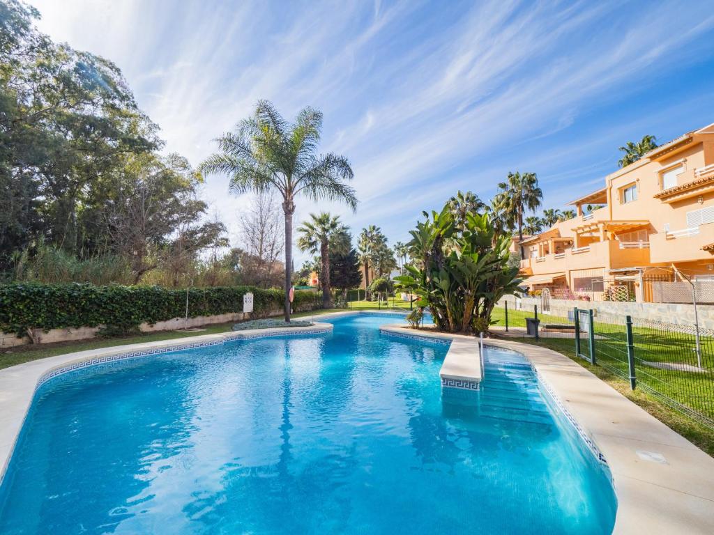 马贝拉Cubo's Cabopino Beach Marbella Apartment的棕榈树别墅内的游泳池