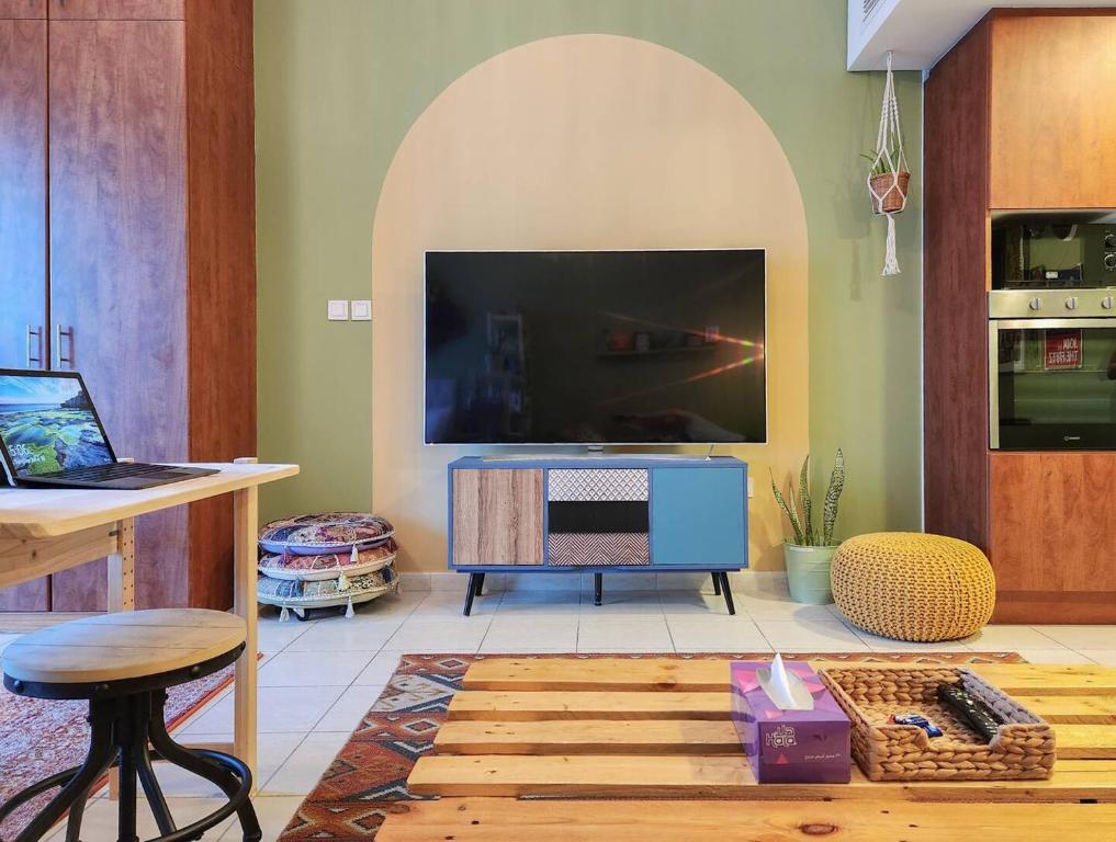 迪拜Rustic Elegance By The Lake Studio Cabin In Jlt的客厅配有大电视和桌子