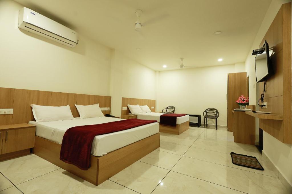 MundakāyamSlice of Heaven的酒店客房设有两张床和一台平面电视。