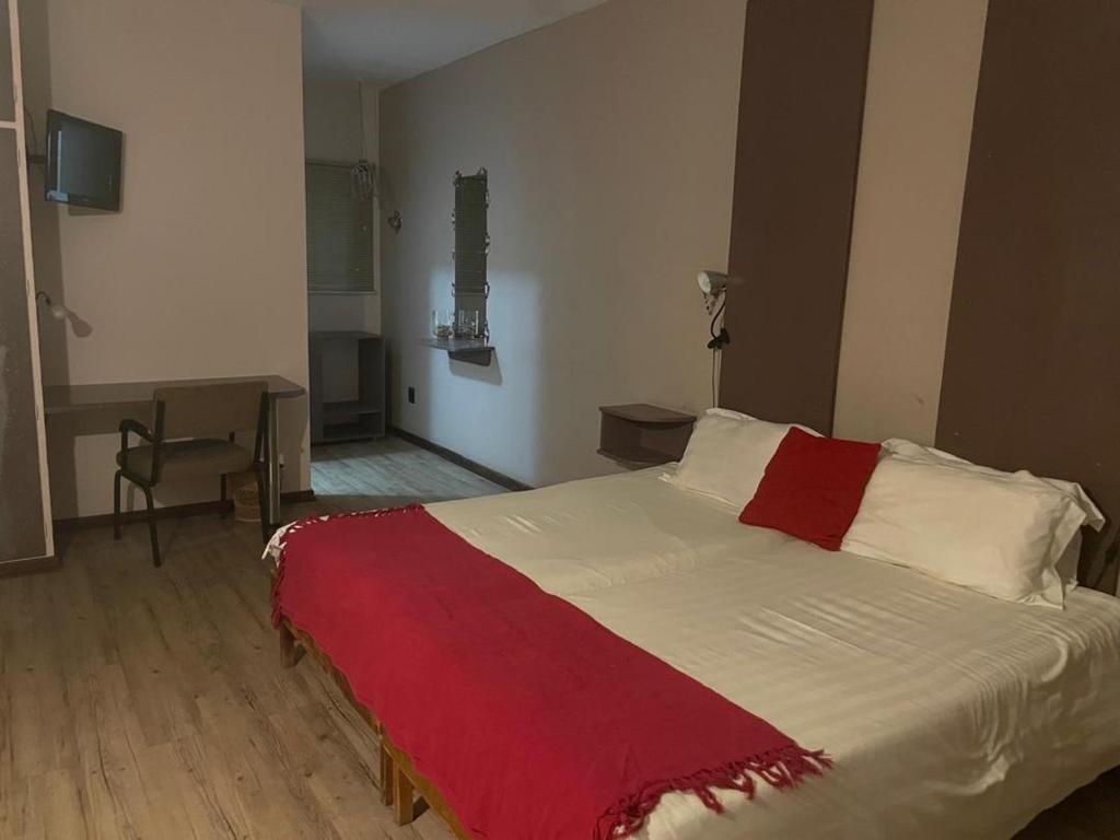 温特和克Hotel Pension Moni的一间卧室配有一张床铺,床上铺有红色毯子