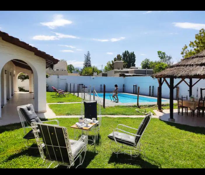卢汉德库约POSADA DE LA LUNA的一个带桌椅的庭院和一个游泳池