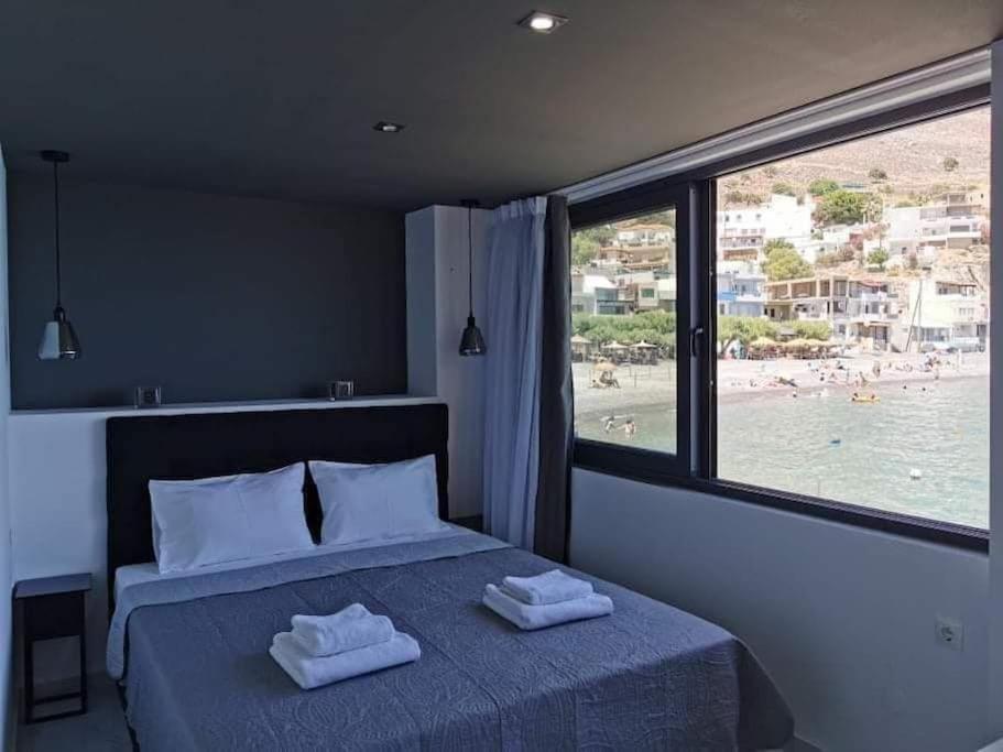 ParánimfoiSunrise Luxury Seaside Apartment的一间卧室配有一张床,享有海滩美景