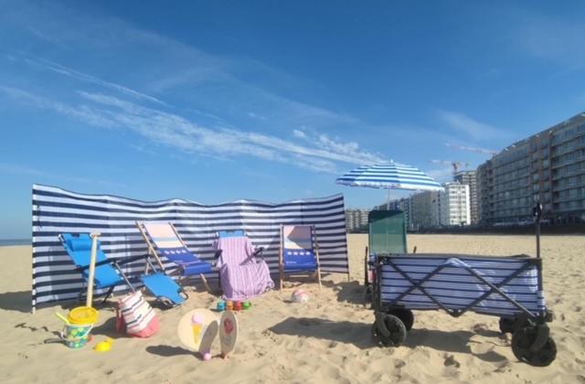 奥斯坦德Be at Sea in Ostend all-in luxury apartment , outdoor pool, side seaview的海滩上的一组椅子和一把遮阳伞