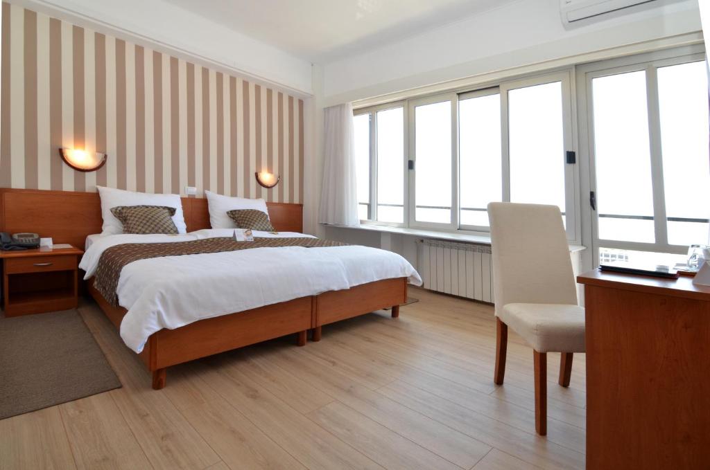 里耶卡奈波德酒店的酒店客房设有一张床、一张书桌和窗户。