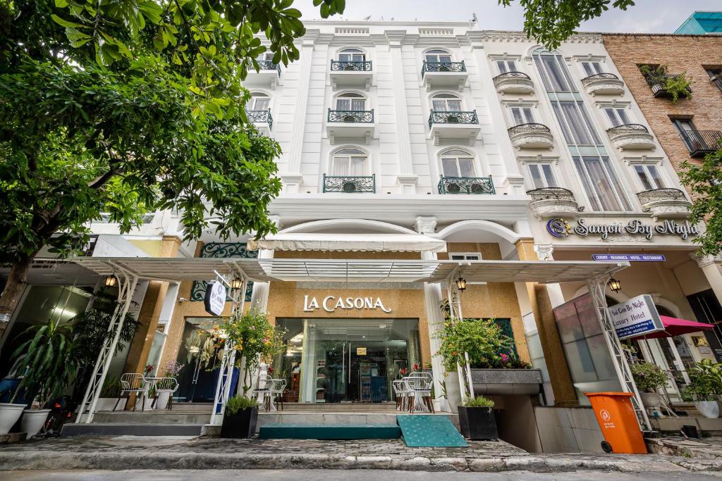 胡志明市La Casona Boutique Hotel的前面有一间商店的大白色建筑