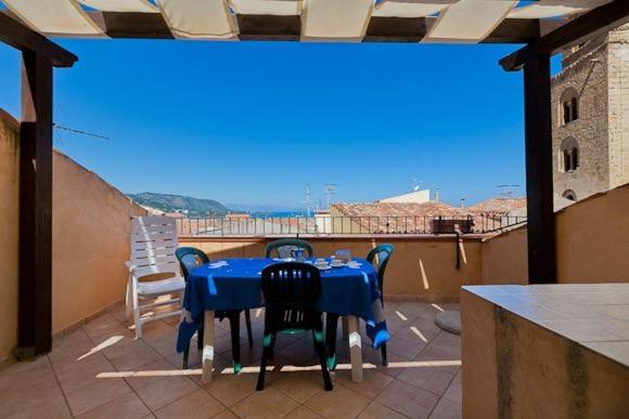 切法卢Terrazza delle mura的阳台上配有蓝色的桌椅