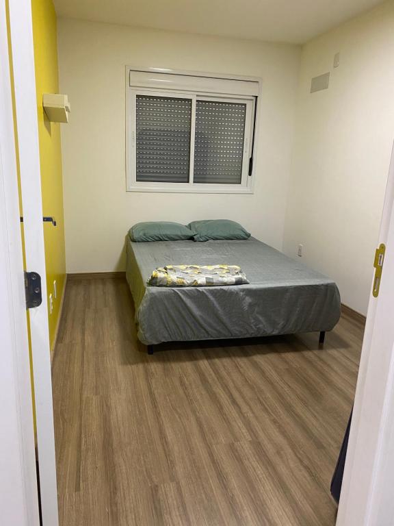 佩洛塔斯Apartamento acqua的一间卧室设有一张床和一个窗口