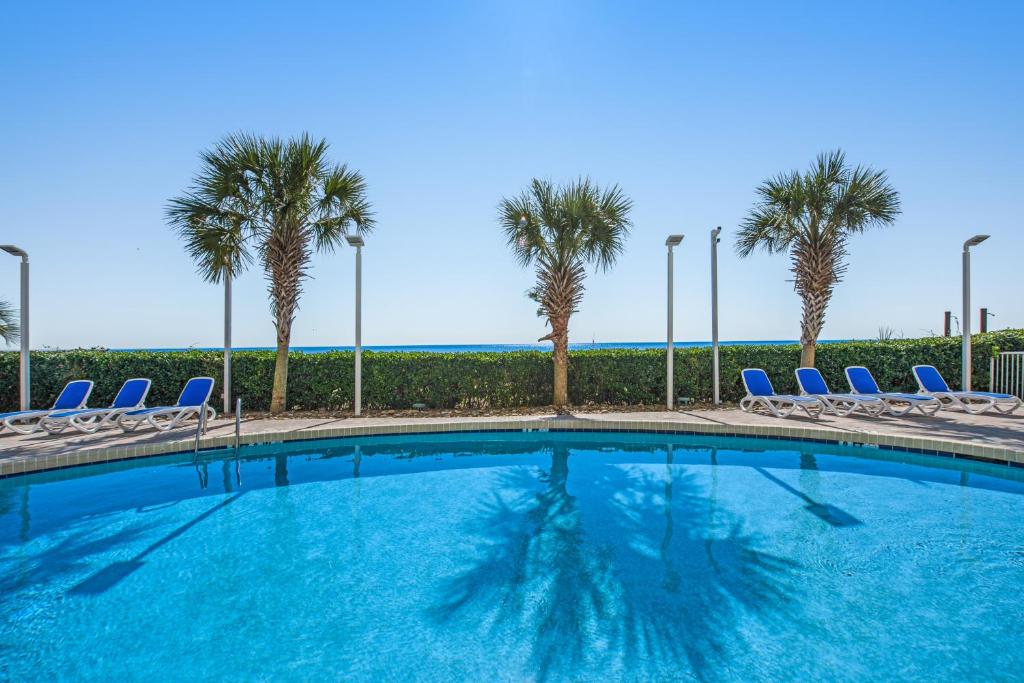 默特尔比奇Oceanview,Modern, Luxury, Carolinian Resort的一个带椅子的游泳池,棕榈树