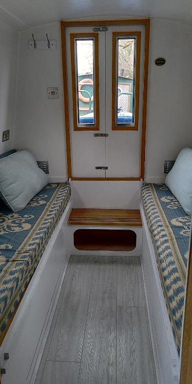 伦敦Boutique Canal Narrow Boat London的小房间设有两张床和两个窗户