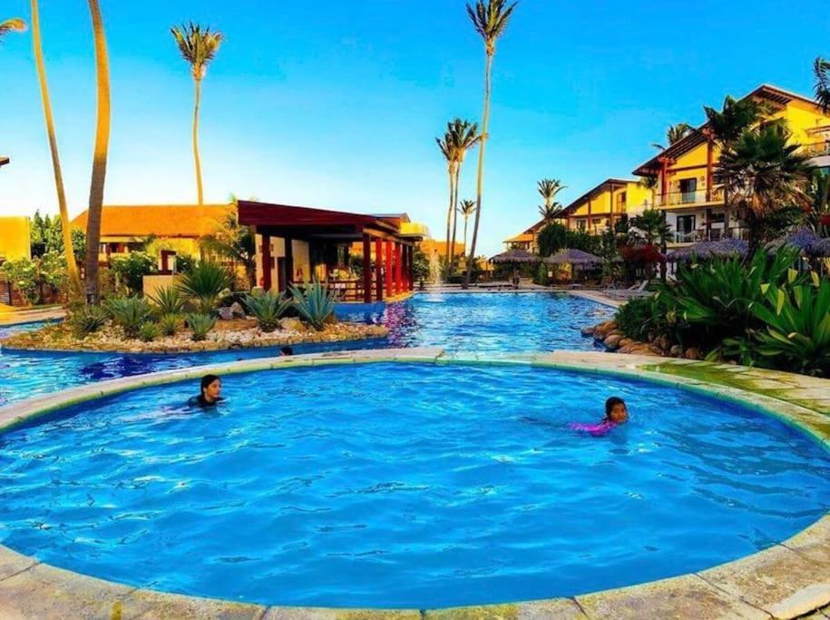 São Gonçalo do AmaranteCasa em resort na Taiba的两人在度假村的游泳池游泳