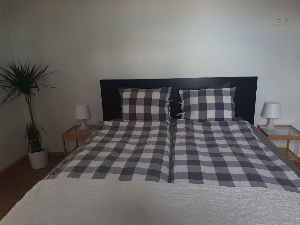 塞尔福斯Vorsabær Apartment的一张带黑白交织毯和枕头的床