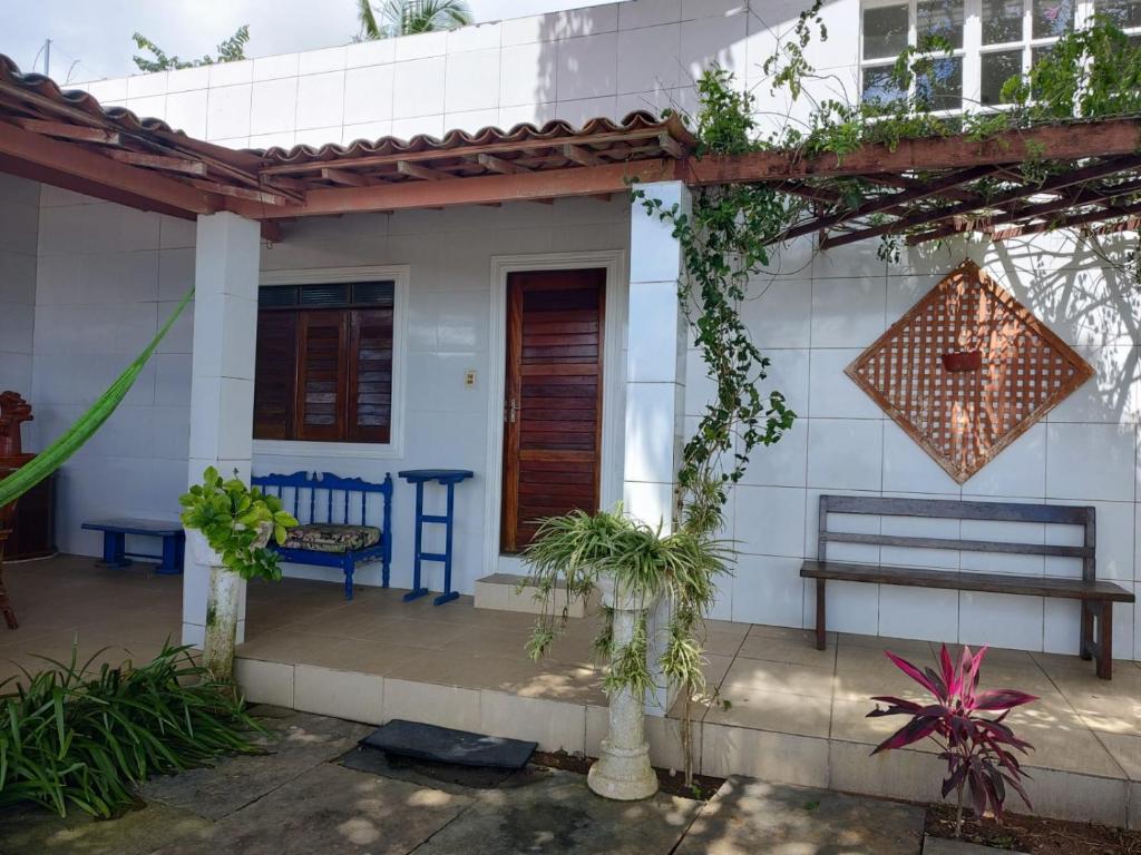 维索萨-杜塞阿拉VIVENDA JUAREZ的白色的房子,设有长凳和门廊