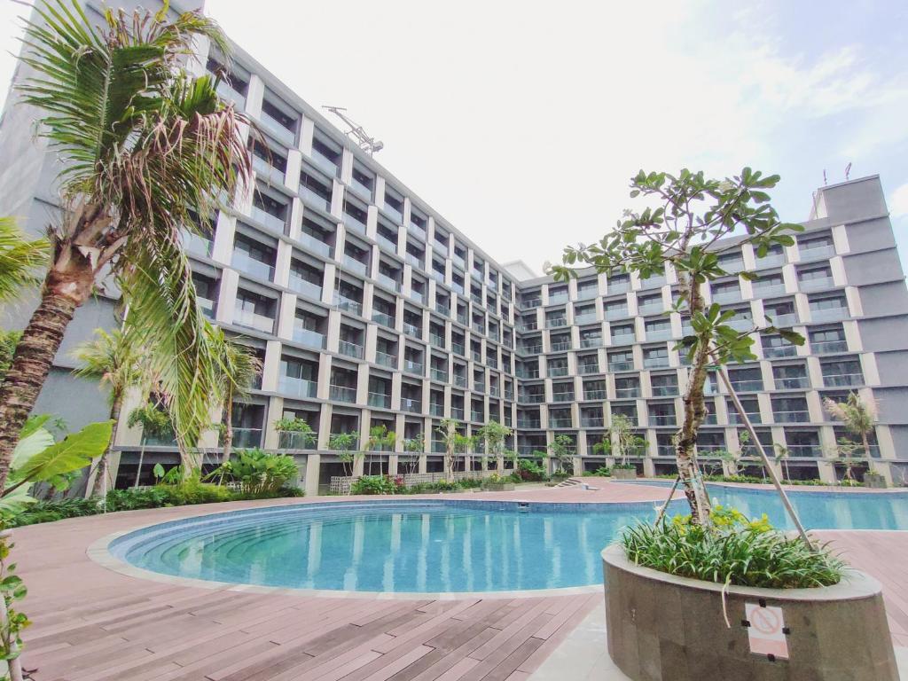 Sepinggang-besarApartemen Skylounge Balikpapan 2BR的一座大型公寓楼,设有游泳池和棕榈树