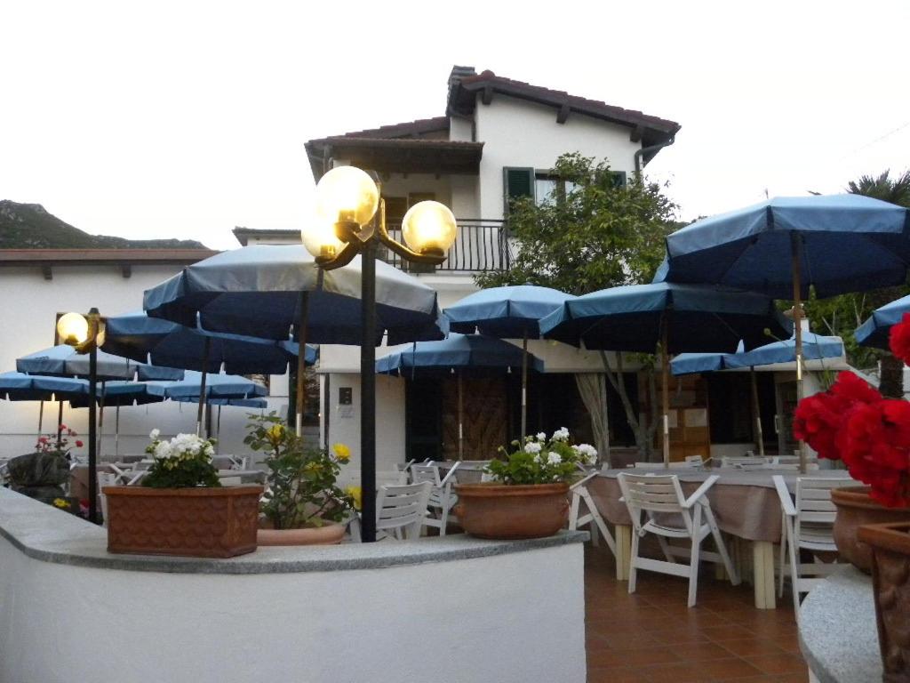 瑟克罗Locanda dell'Amicizia的一个带蓝伞和桌椅的庭院