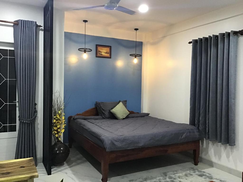 Phumĭ Ta PhŭlKittya Homestay的一间卧室配有一张蓝色墙壁的床