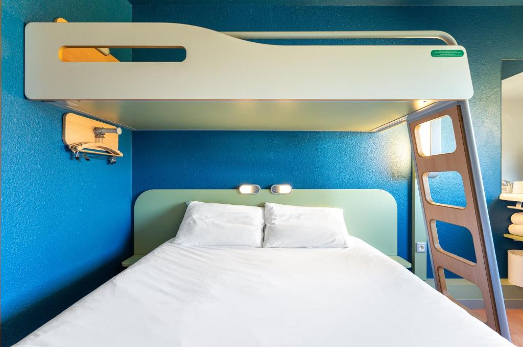 马孔梅肯北宜必思快捷酒店的蓝色客房的一张床位,配有一张双层床