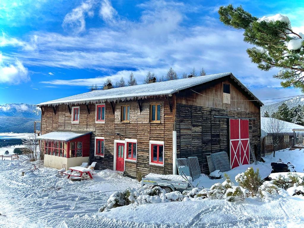 安格勒Gîte Ranch Le Serpolet的雪中带红色门的小木屋