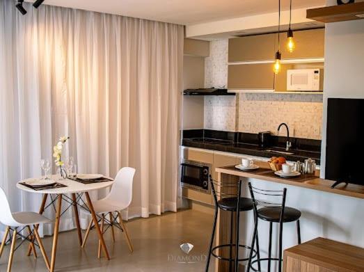 圣洛伦索Diamond Hotéis e Flats的厨房配有桌子、椅子和柜台