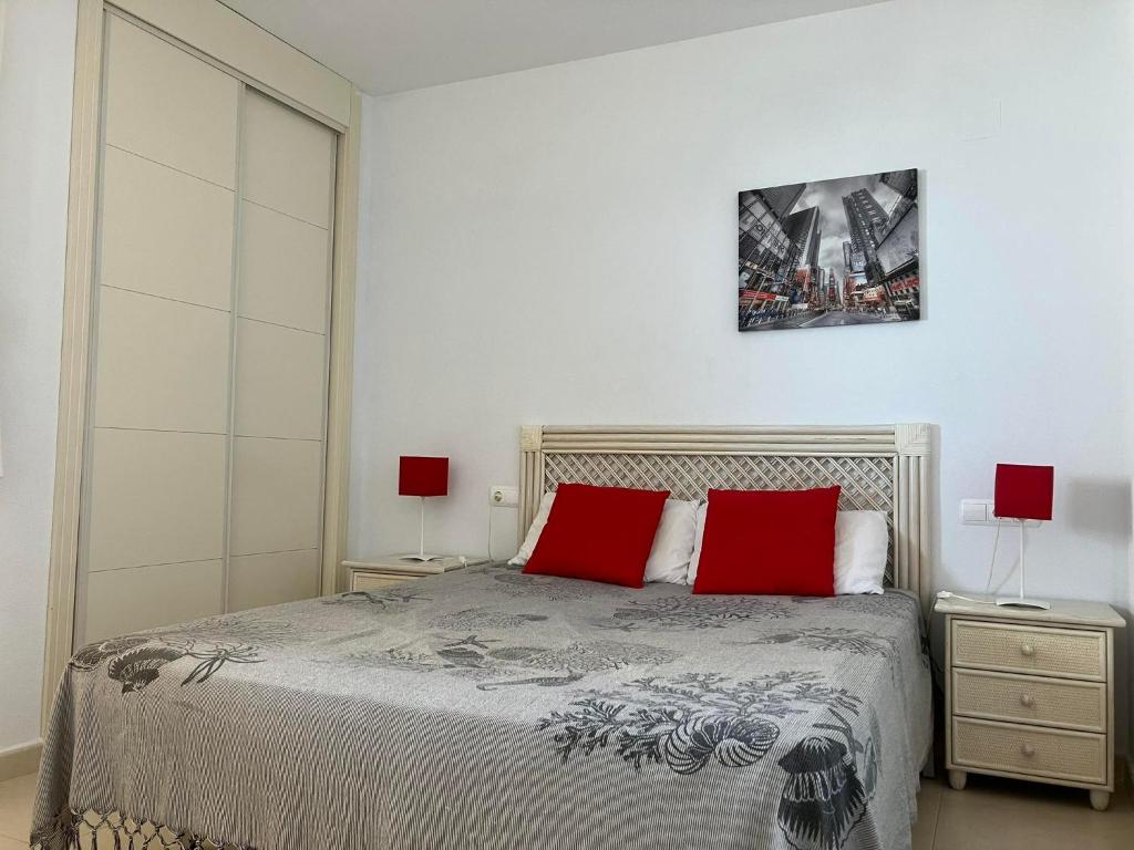 卡尔佩Ambar Monica Apartment的一间卧室配有一张带两个红色枕头的床