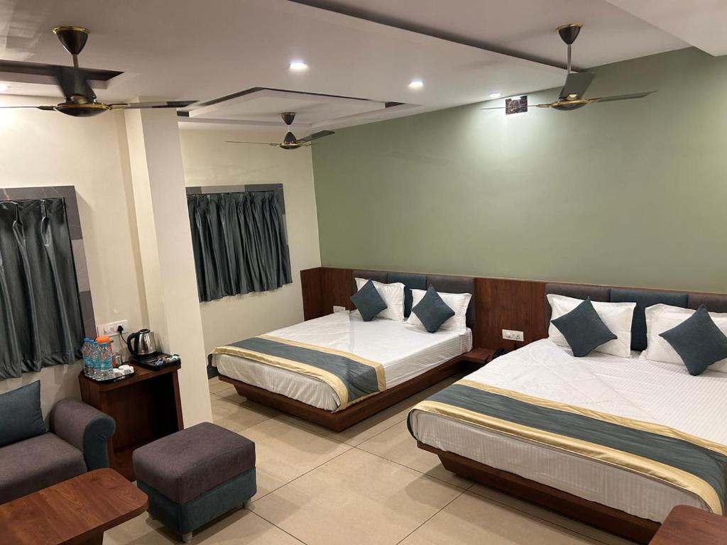 德奥加尔Hotel Omkareshwar Inn的酒店客房,配有两张床和椅子