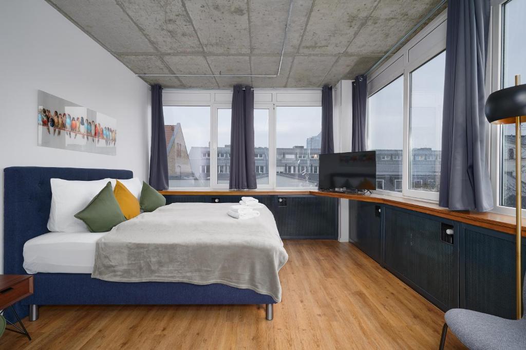 莱比锡Stylisches Studio im Herzen Leipzigs的一间卧室配有一张带蓝色橱柜和窗户的床。