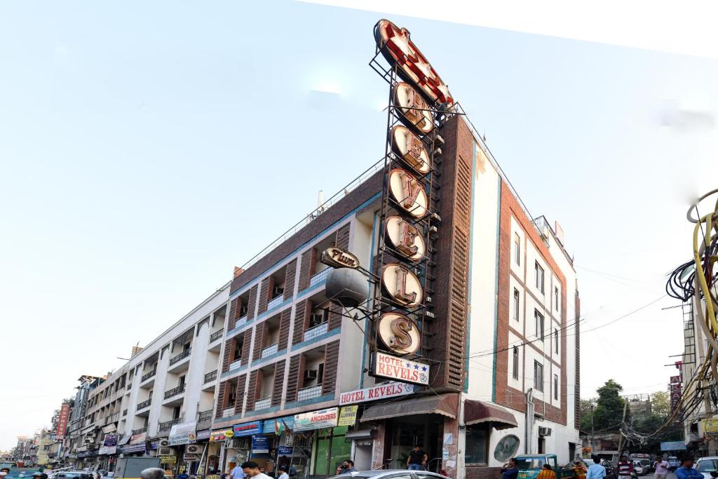 新德里Hotel By Yellow Revels Plum的城市街道上一座带剧院标志的大型建筑