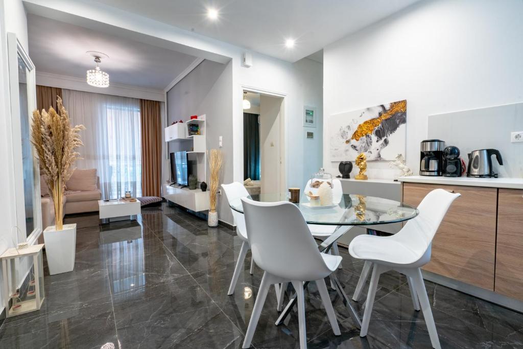 雅典Neo Irakleio train st. 1 bedrm 4 pers. apartment的厨房以及带玻璃桌和白色椅子的客厅。