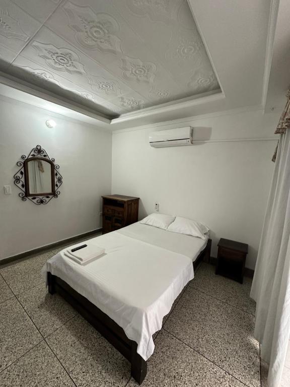 库库塔Apartaestudio Luiggis Cucuta的卧室配有白色的床和镜子