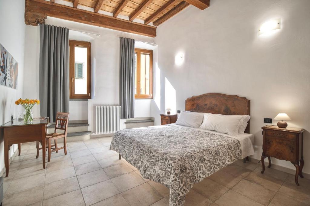 佛罗伦萨San Niccolò Luxury Apartment的一间卧室配有一张床、一张桌子和一张书桌