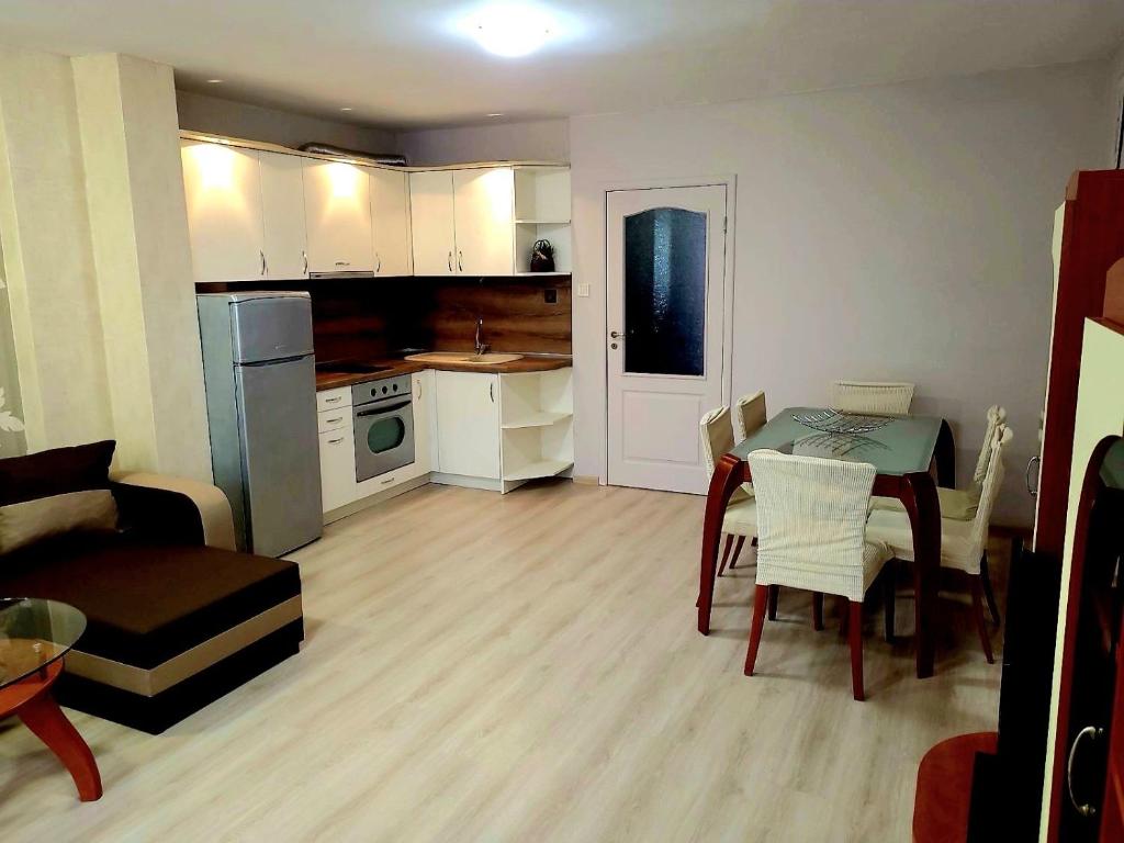 布尔加斯Lux Apartment Sisi的小厨房以及带桌椅的客厅。