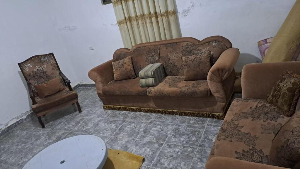 Umm el ‘Amadمادبا شارع عمان مادبا الشرقي的客厅配有沙发和两把椅子