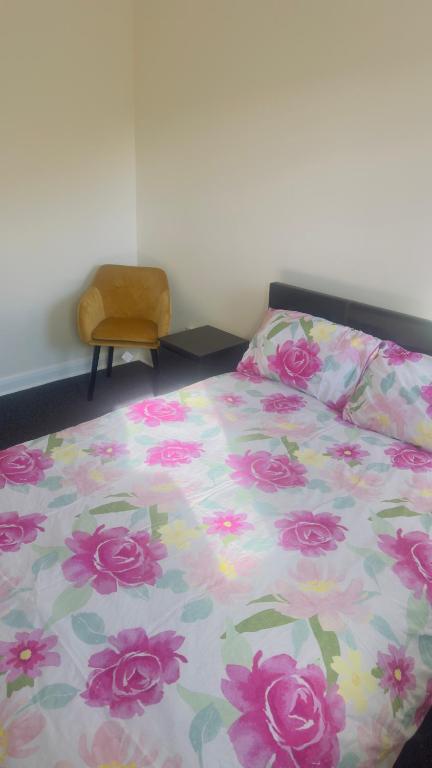 威廉堡Budget Rooms的一间卧室配有一张带花卉棉被的床