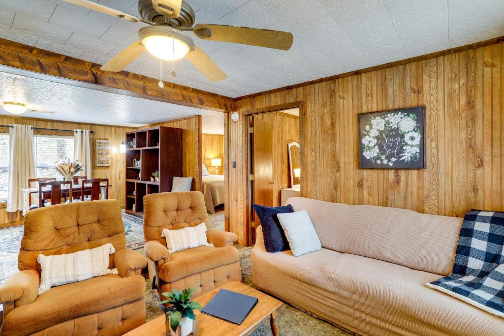 Heber SpringsHeber Springs Cabin with Deck 3 Mi to Sugarloaf Mtn的客厅配有沙发、椅子和吊扇