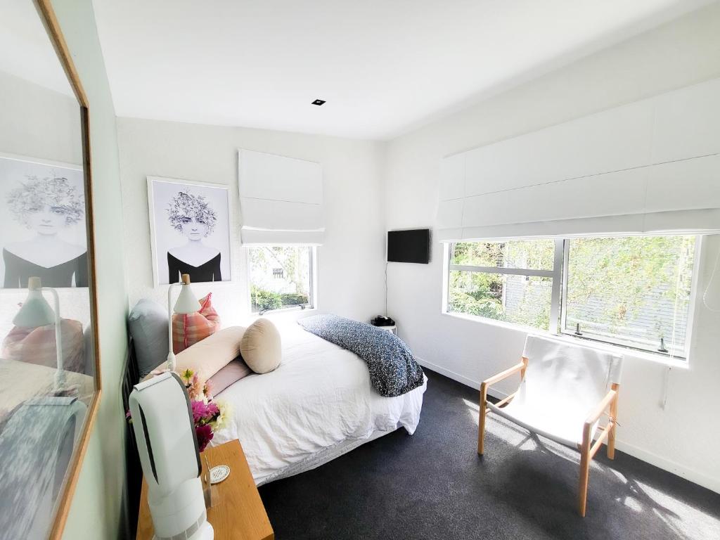 奥克兰Inner City Sunny Bedroom的白色卧室配有床和椅子