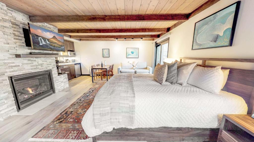 斯诺马斯村Willows - CoralTree Residence Collection的一间卧室设有一张大床和一个壁炉